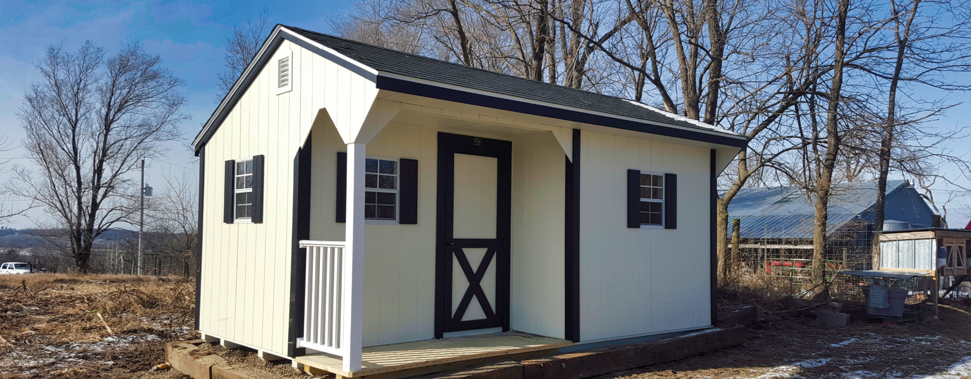 Wooden Backyard Shed - White wood siding with black-trimmed door and corners - three visible windows with black shutters