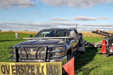 Angled view of one of our heavy-duty shed moving trucks with an “Oversize Load” yellow metal banner