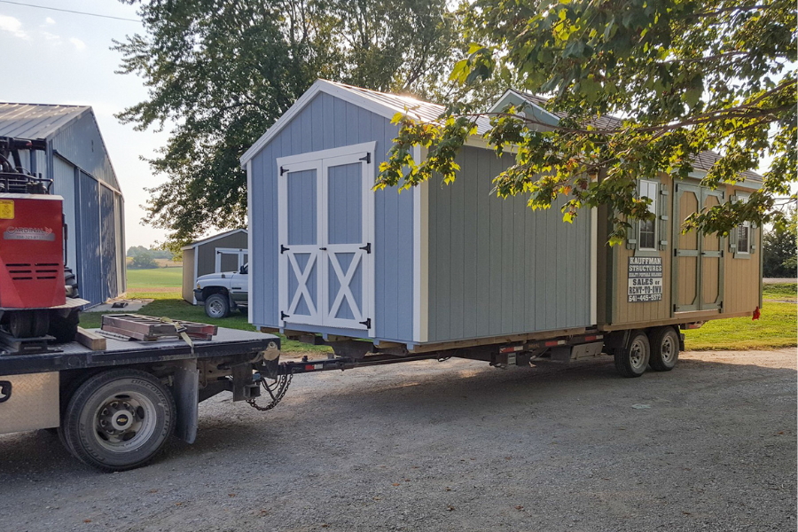 two sheds being moved on property by truck with shed moving permit