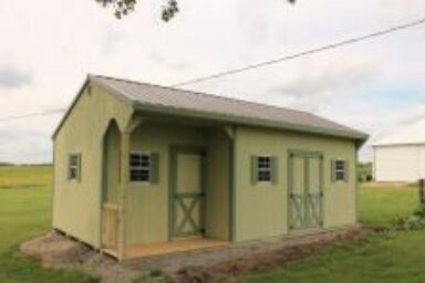 backyard shed - light green wood siding with dark green-trimmed double and single doors and matching shutters on four visible windows beneath brown roof - shed sits on green field of grass