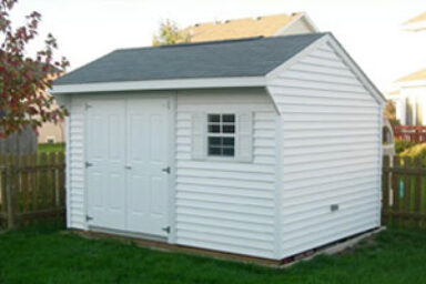 Backyard shed with white siding with matching double doors and window with white shutters beneat gray shingled roof